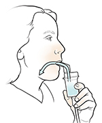 Babaeng lumalanghap ng gamot mula sa nebulizer na may mouthpiece.
